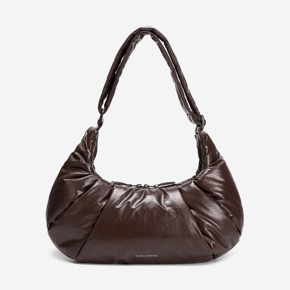 A dark brown shiny Croissant-shaped shoulder bag in polish brown color by Dude & Bestie